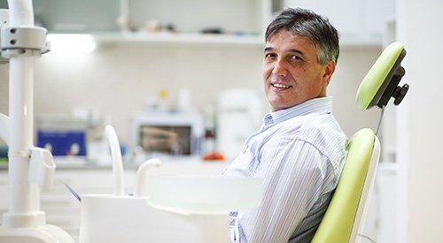 Man smiling while sitting in treatment chair