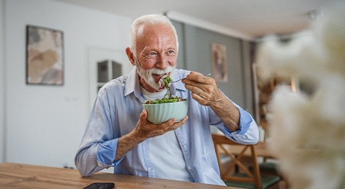 Man smiling while eating lunch at home