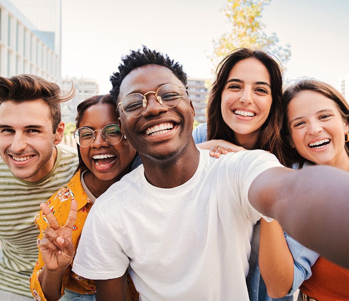 Group of people outside smiling taking selfie