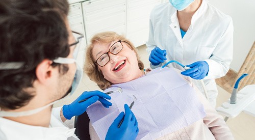 Woman smiling at dentist while sitting in treatment chair