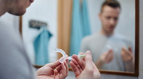 Man applying whitening gel to custom-fitted applicator tray