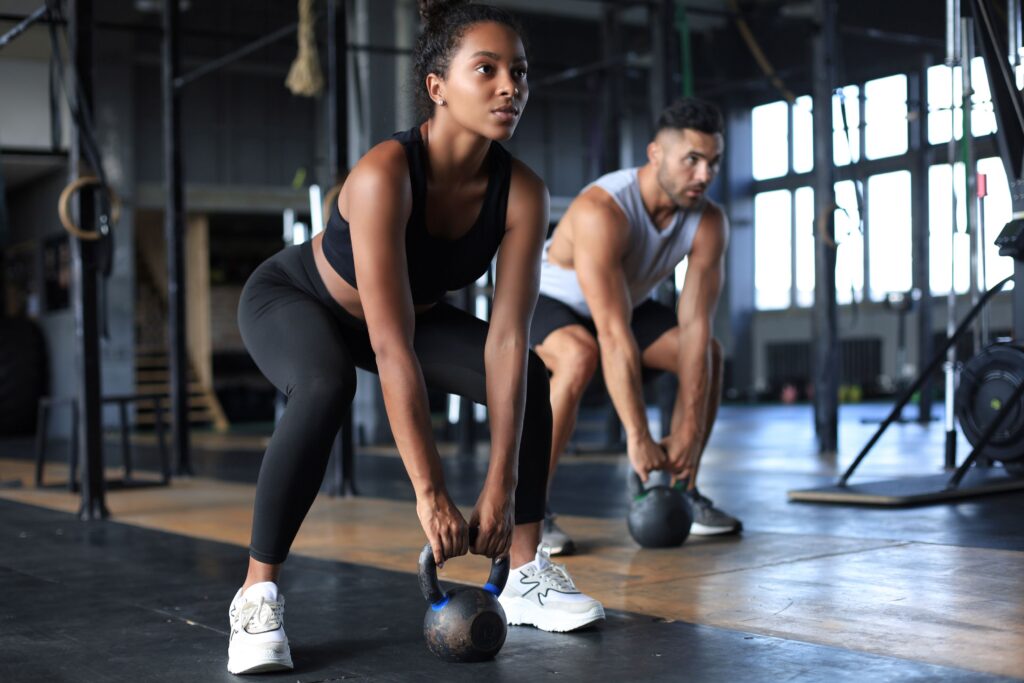 Man and woman at gym with kettle balls