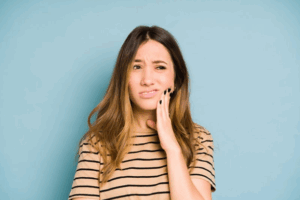 Woman rubbing her aching jaw