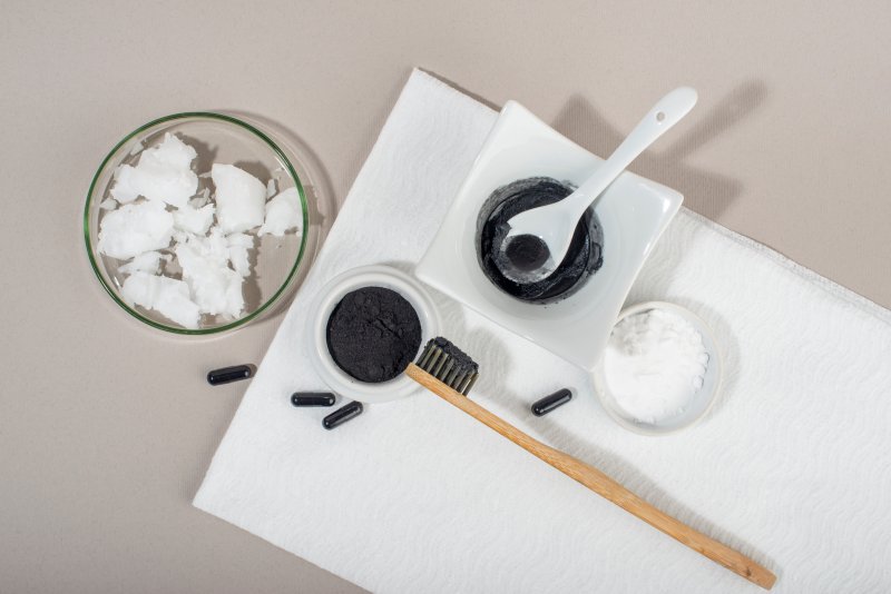 Charcoal, toothbrush, and baking soda laid out for DIY teeth whitening