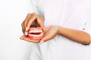 Dentist holding set of dentures.